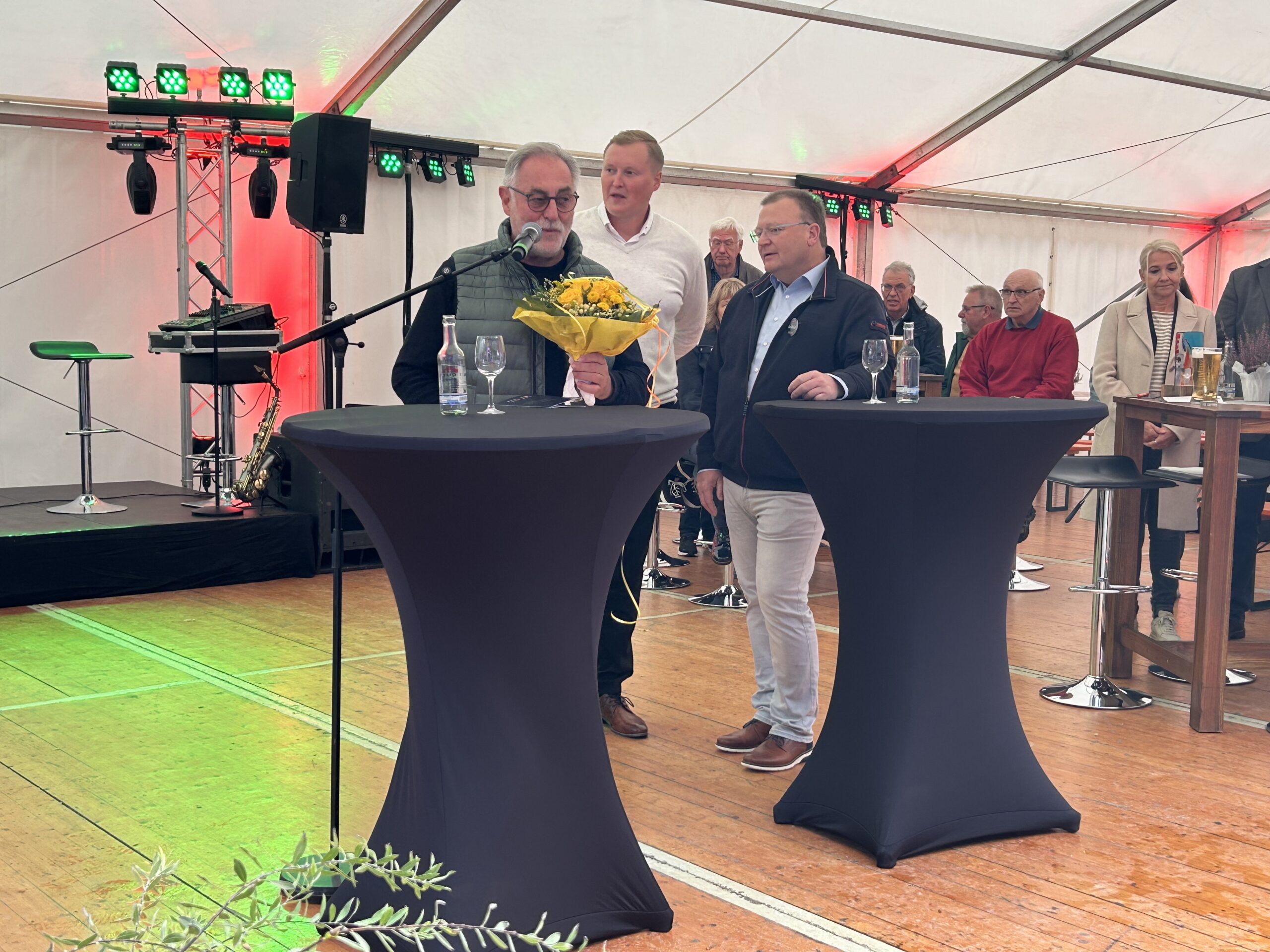 Paul Barella, GF Barella und Harald Samel (ehemaliger GF) am Mikrofon auf der Bühne im Festzelt